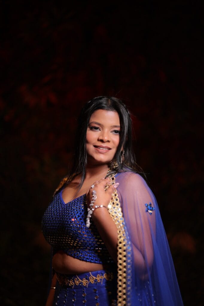 Woman posing in blue traditional outfit.