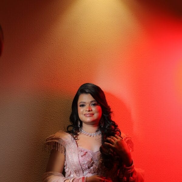Bride posing in a pink embellished gown during an indoor photoshoot.