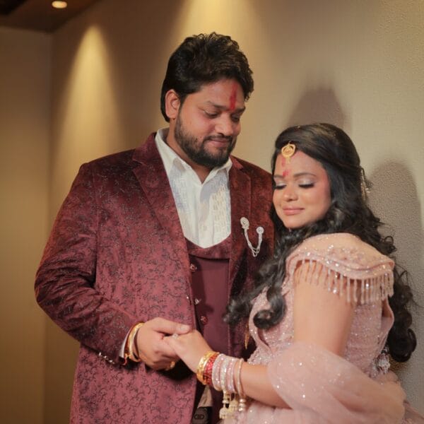 Bride and groom posing together in soft indoor lighting.