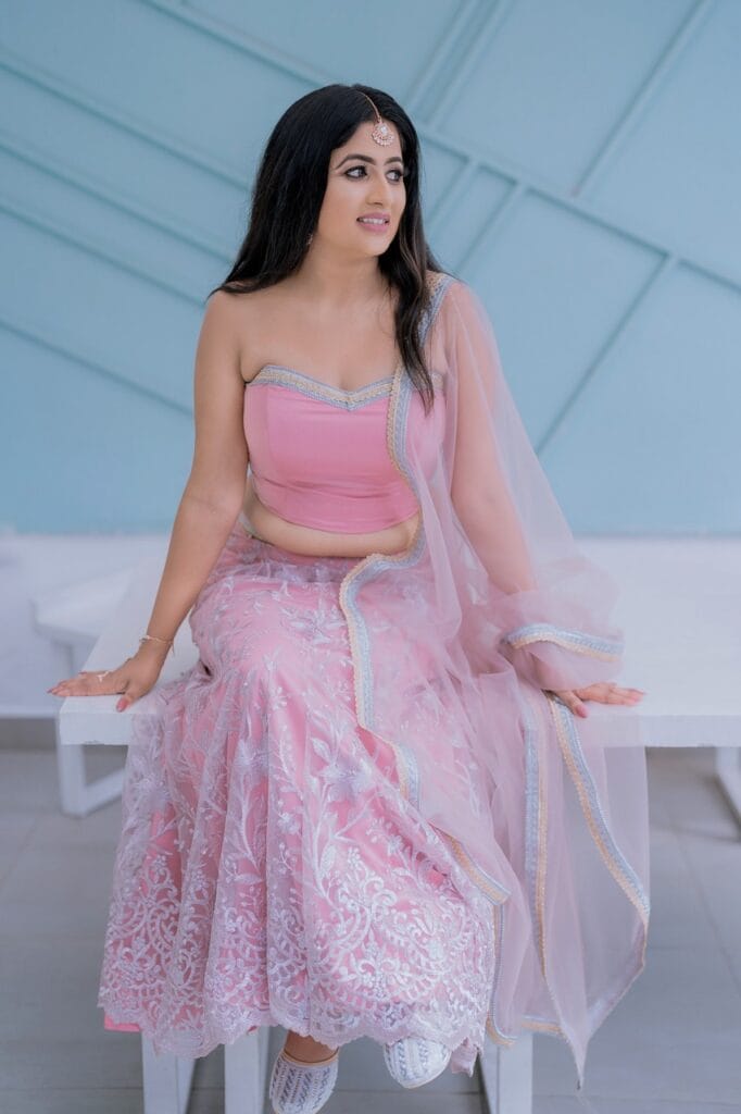 Traditional photoshoot featuring a woman in a pink ensemble.